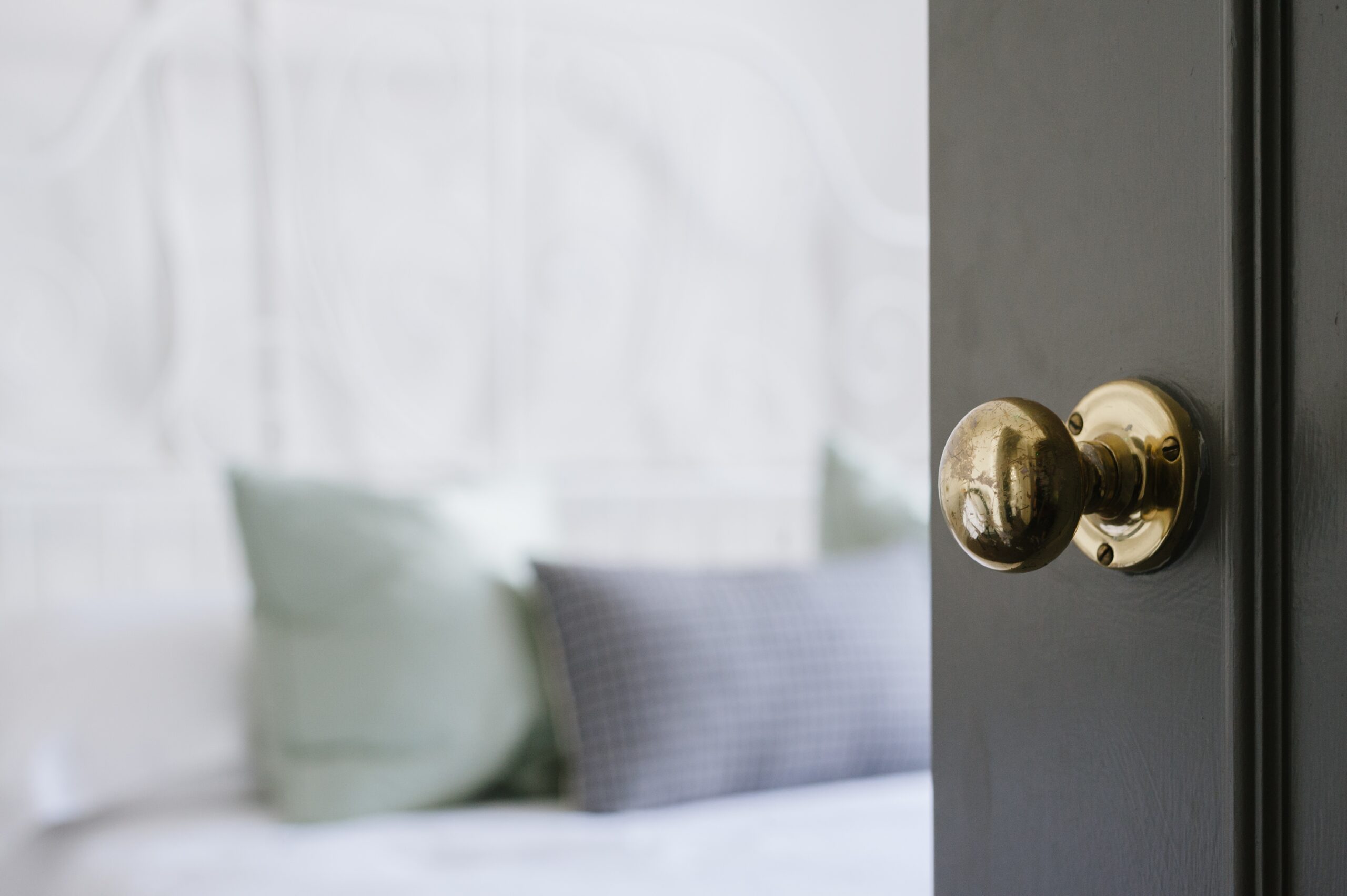 A closeup shot of a gold door knob on a black door