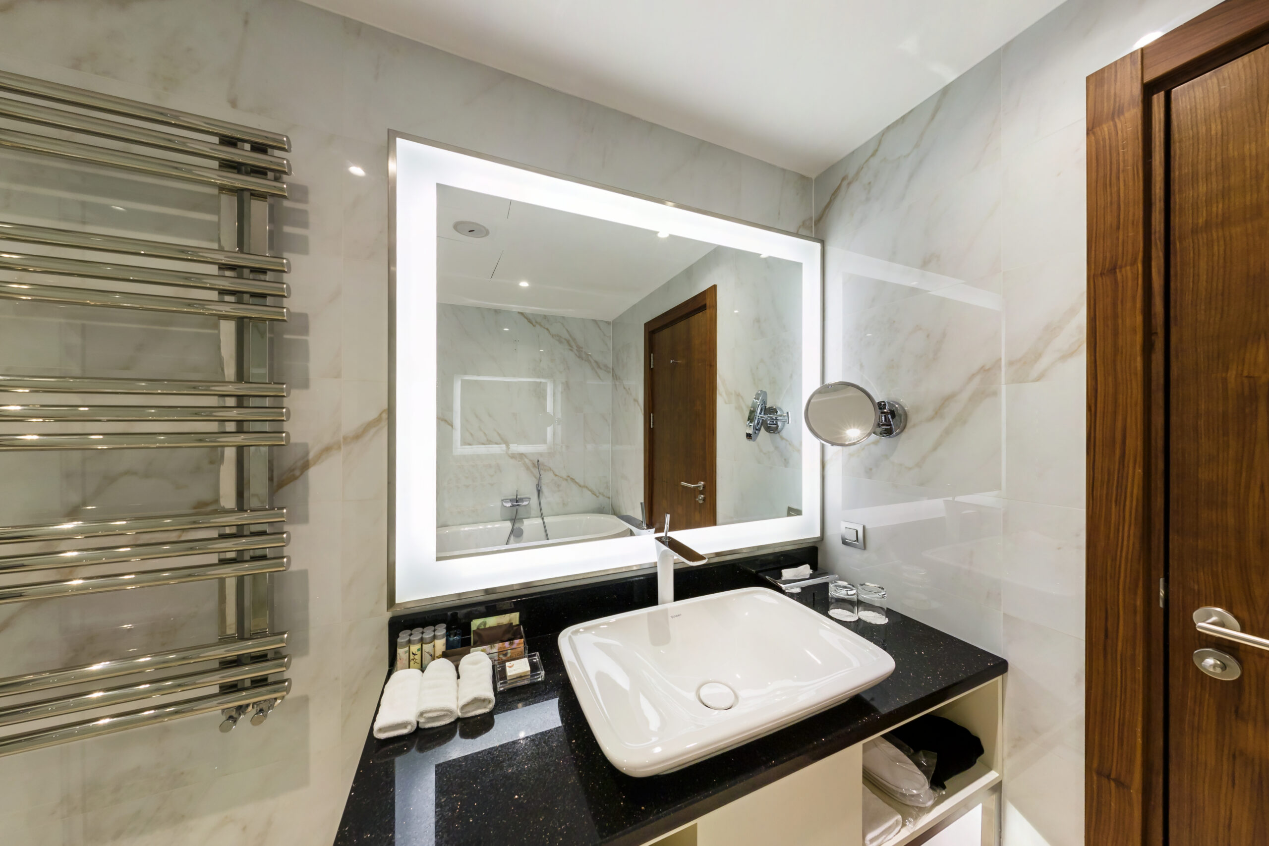 GRODNO, BELARUS - SEPTEMBER 2019: water tap sink with faucet in expensive loft bathroom. detail of a corner shower cabin with wall mount shower attachment