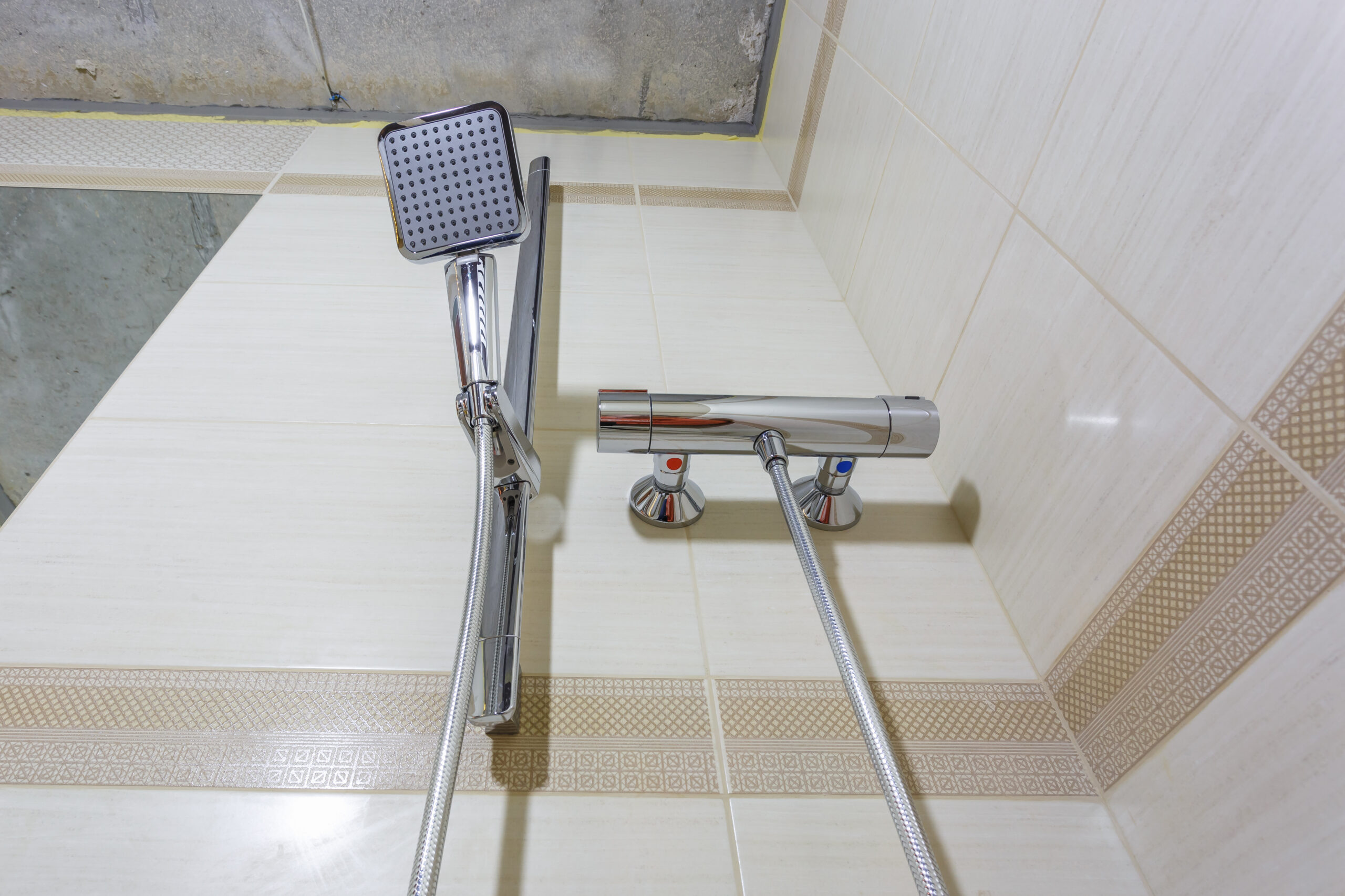 square water tap with faucet in expensive bathroom. detail of a corner shower cabin with wall mount shower attachment